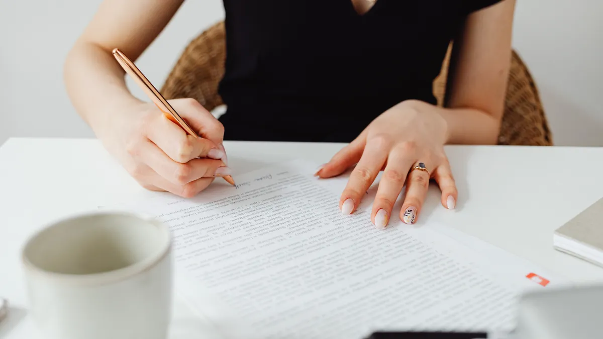 How Premium AI Writing Services Handle Revisions Person proofreading a printed document with a pen