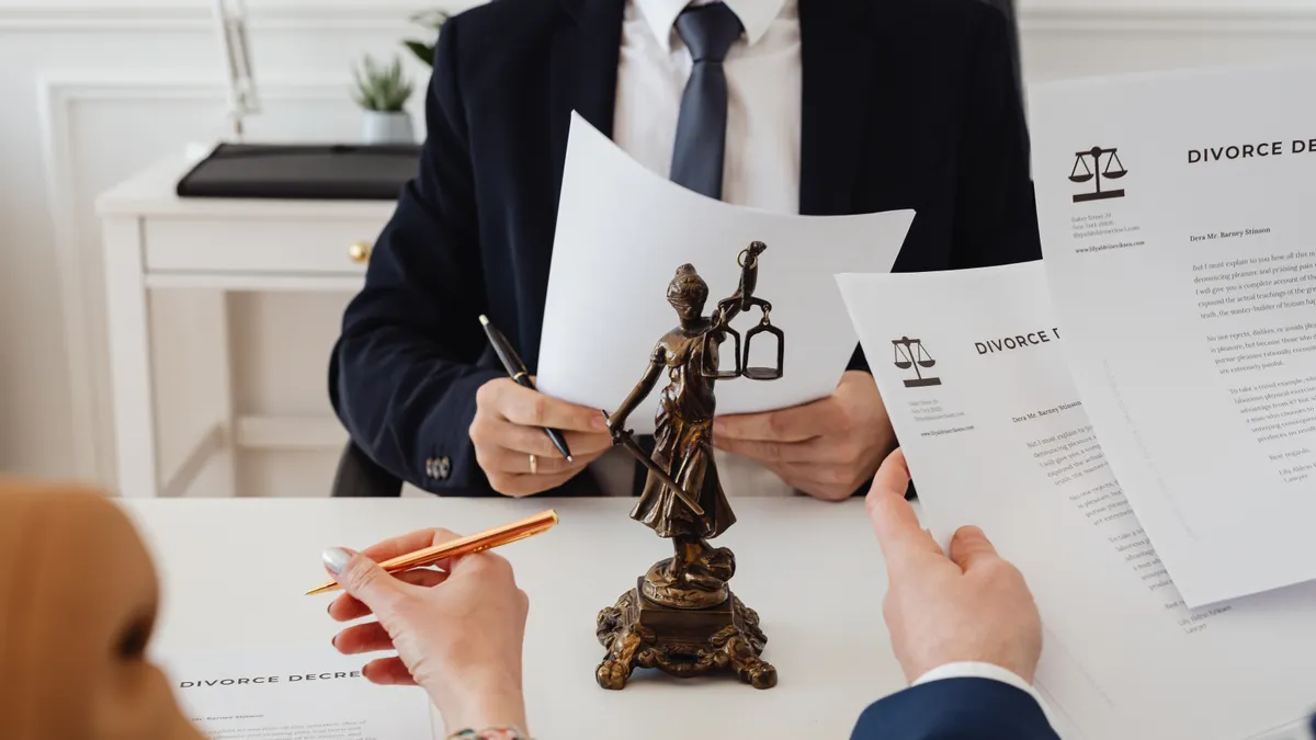 lawyer meeting clients with legal documents and justice statue