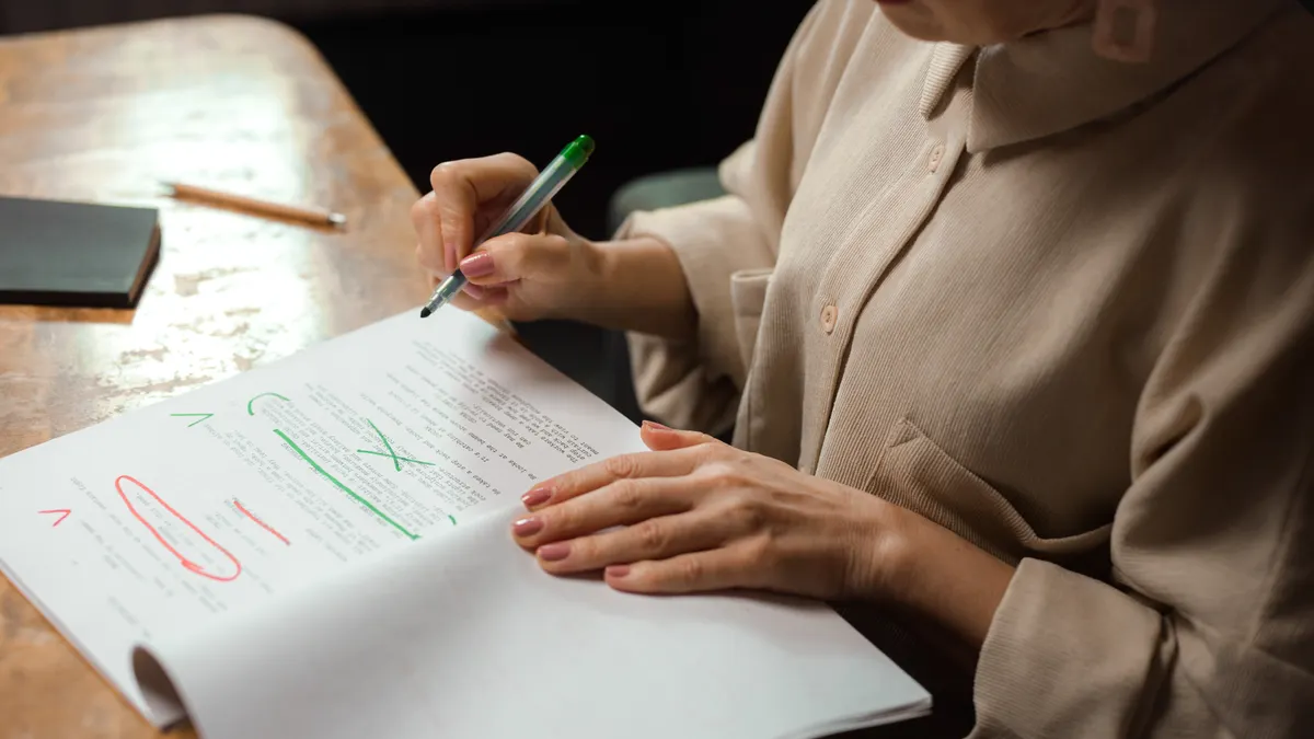 Person marking a draft with red and green editorial corrections